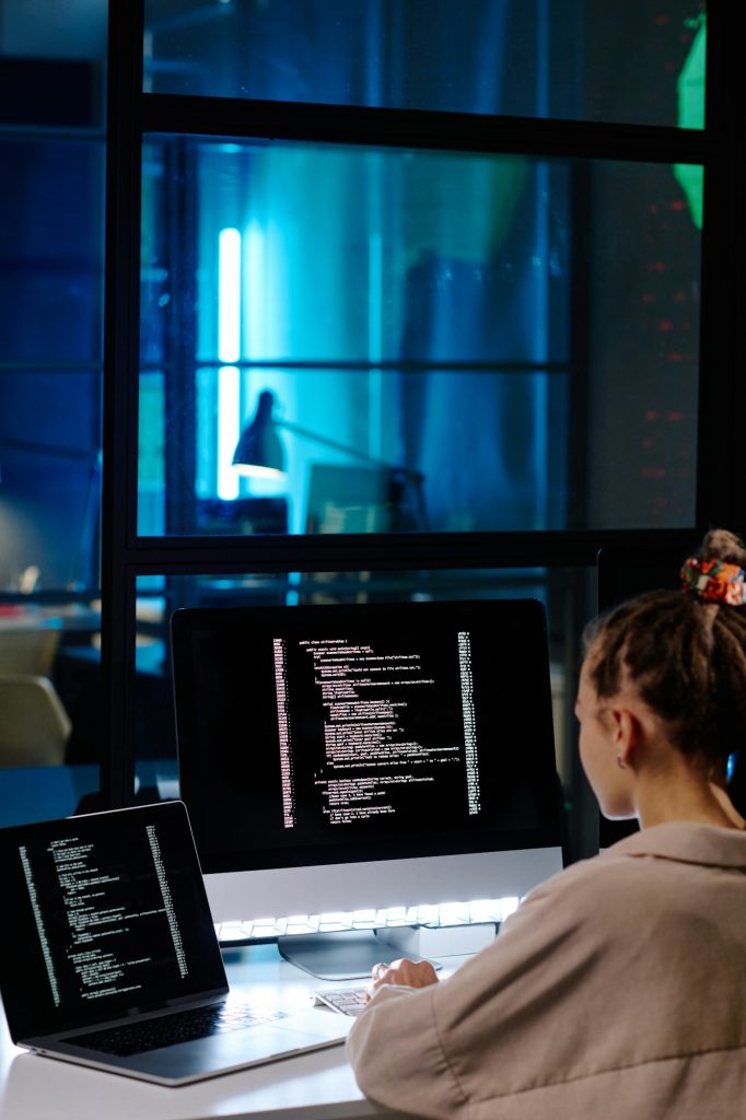 Young female software developer or programmer working with coded data